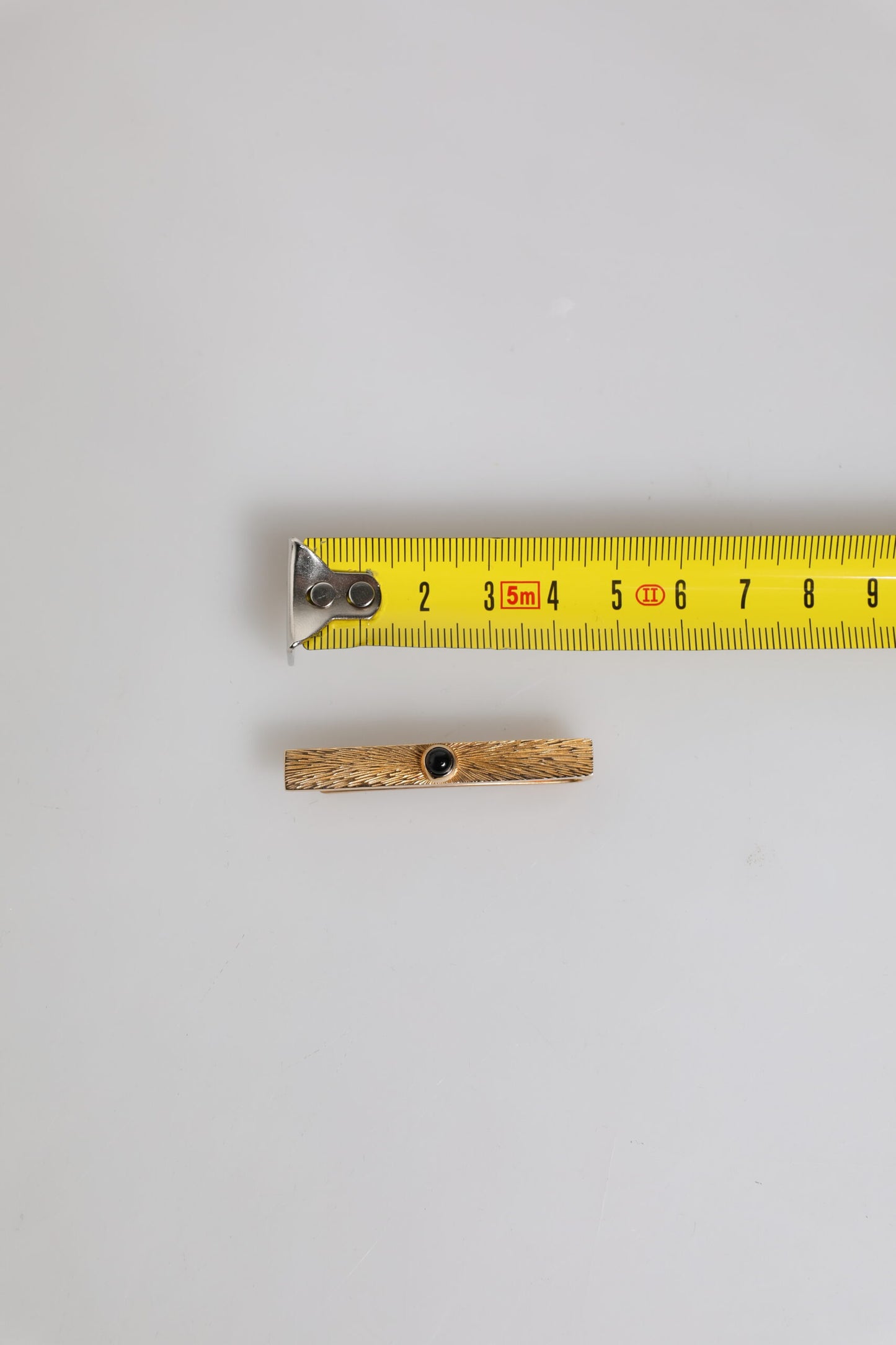 Dolce &amp; Gabbana – Krawattenklammer aus Messing in Goldtönen mit schwarzem Saphir